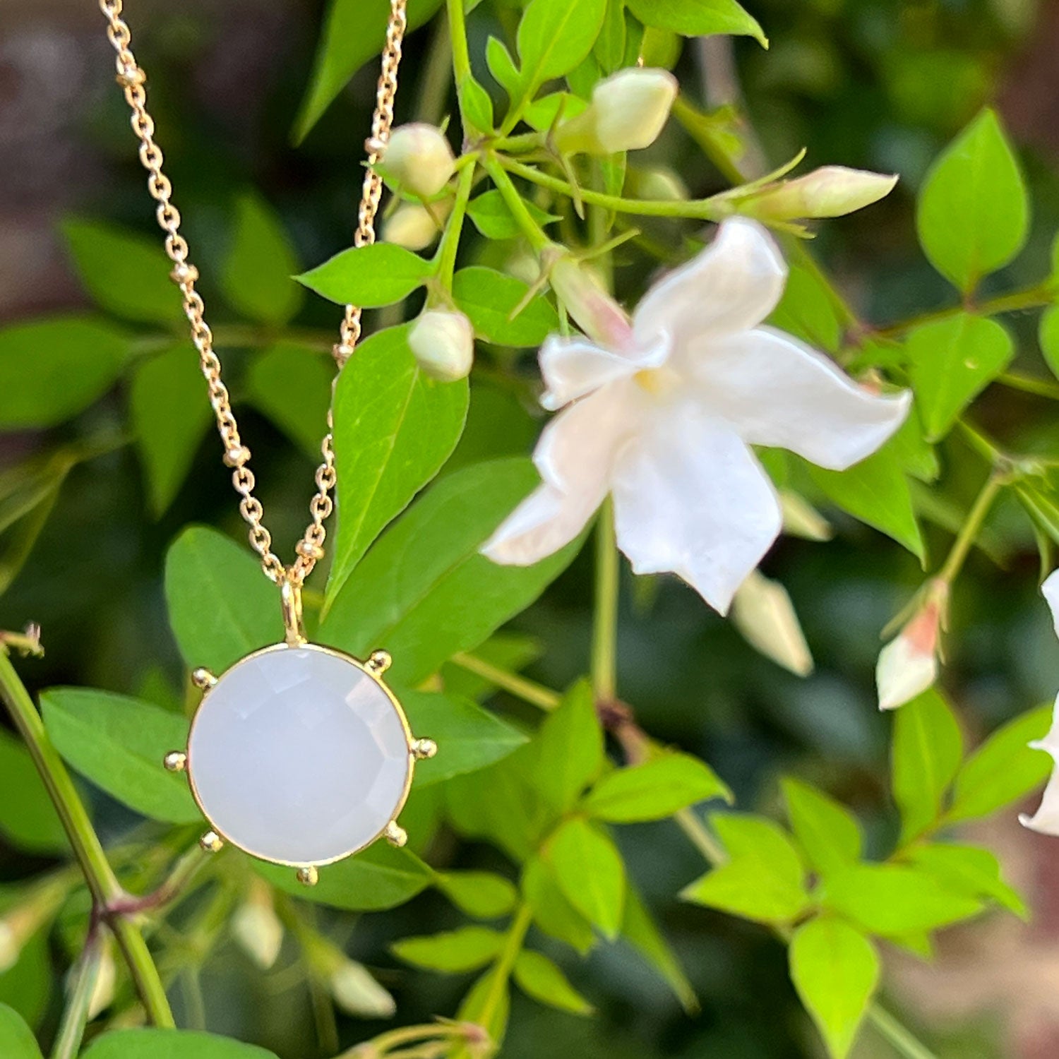 White Chalcedony Pendant next to some white flowers