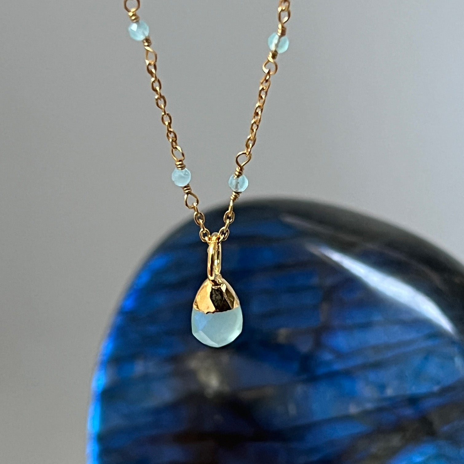 Gold-plated Aqua Chalcedony Pendant on Fancy Rosary Chain with a dark blue crystal in the background