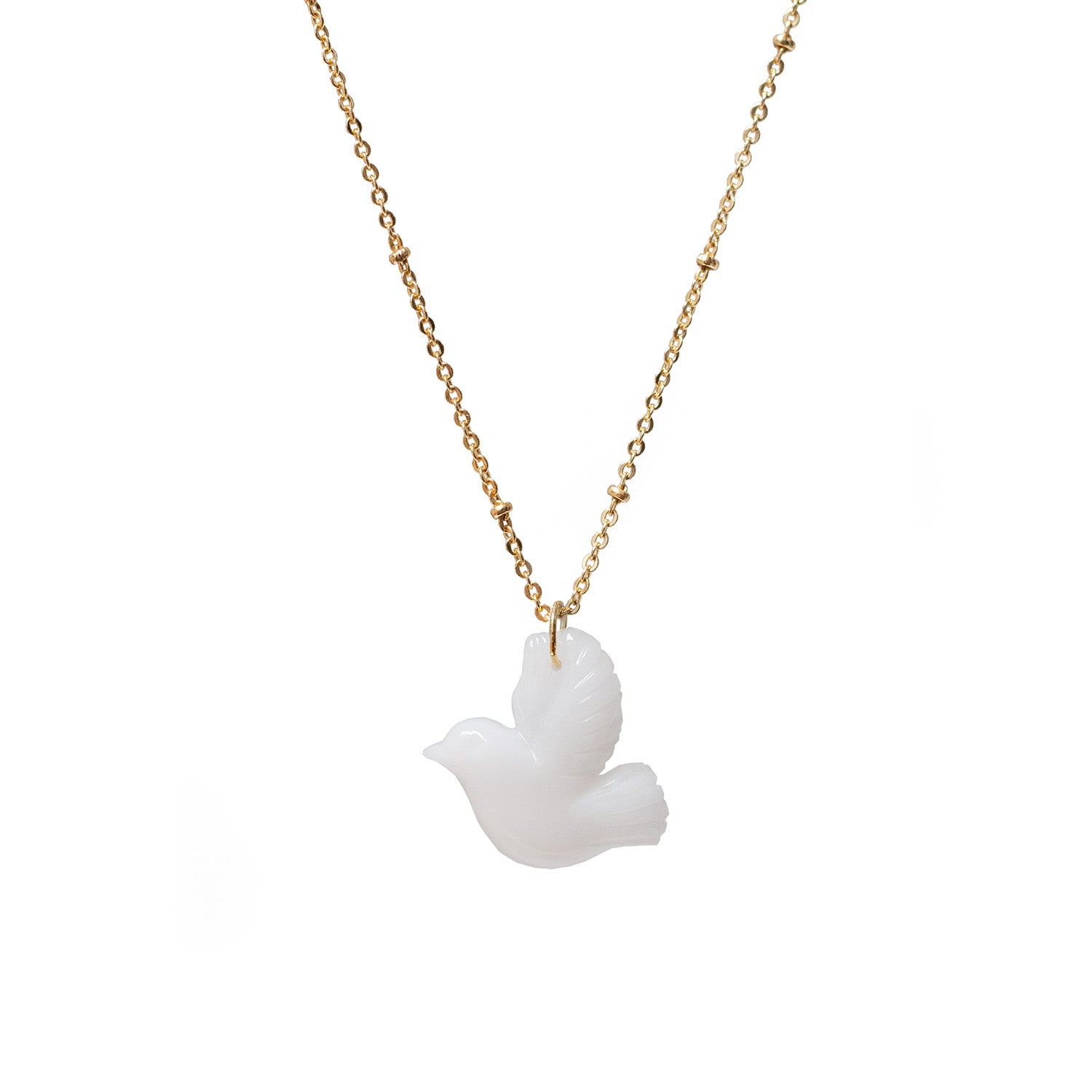 A white agate carved in the shape of a dove, suspended from a gold-plated chain.