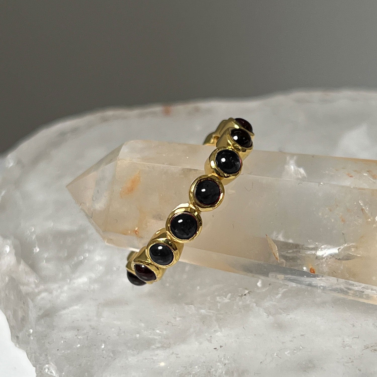 Gold eternity eternity vermeil ring with black onyx stones, with crystal background