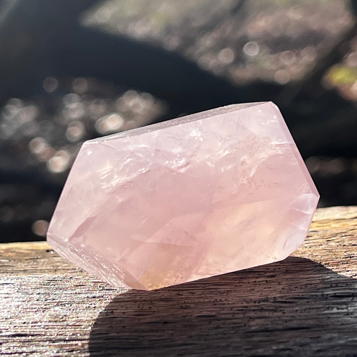 Rose quartz crystal point lying on it's side
