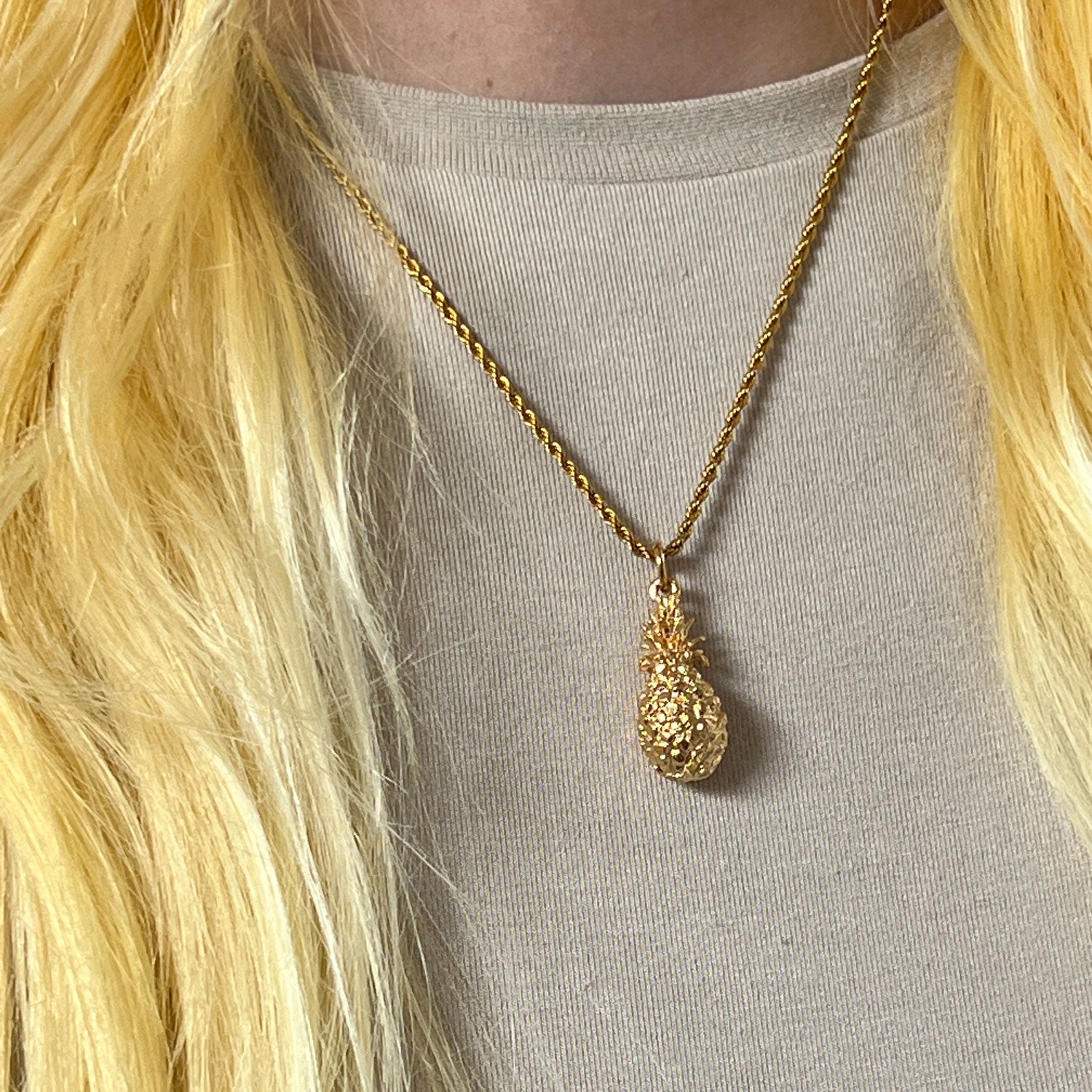 22ct Gold Plated Pineapple Charm Pendant on a chain worn on a model with an ivory jumper