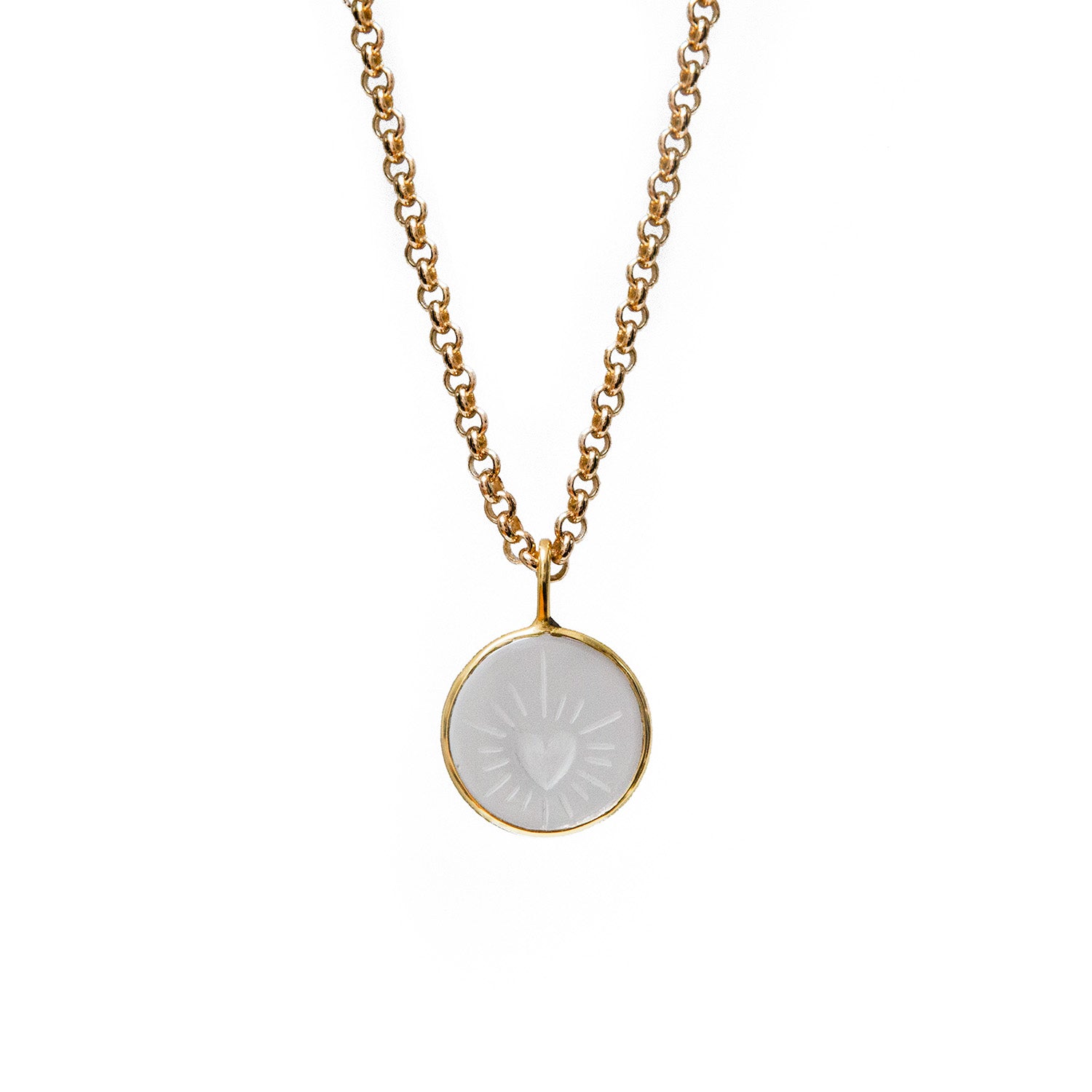 Gold necklace with a carved rock crystal pendant on a white background