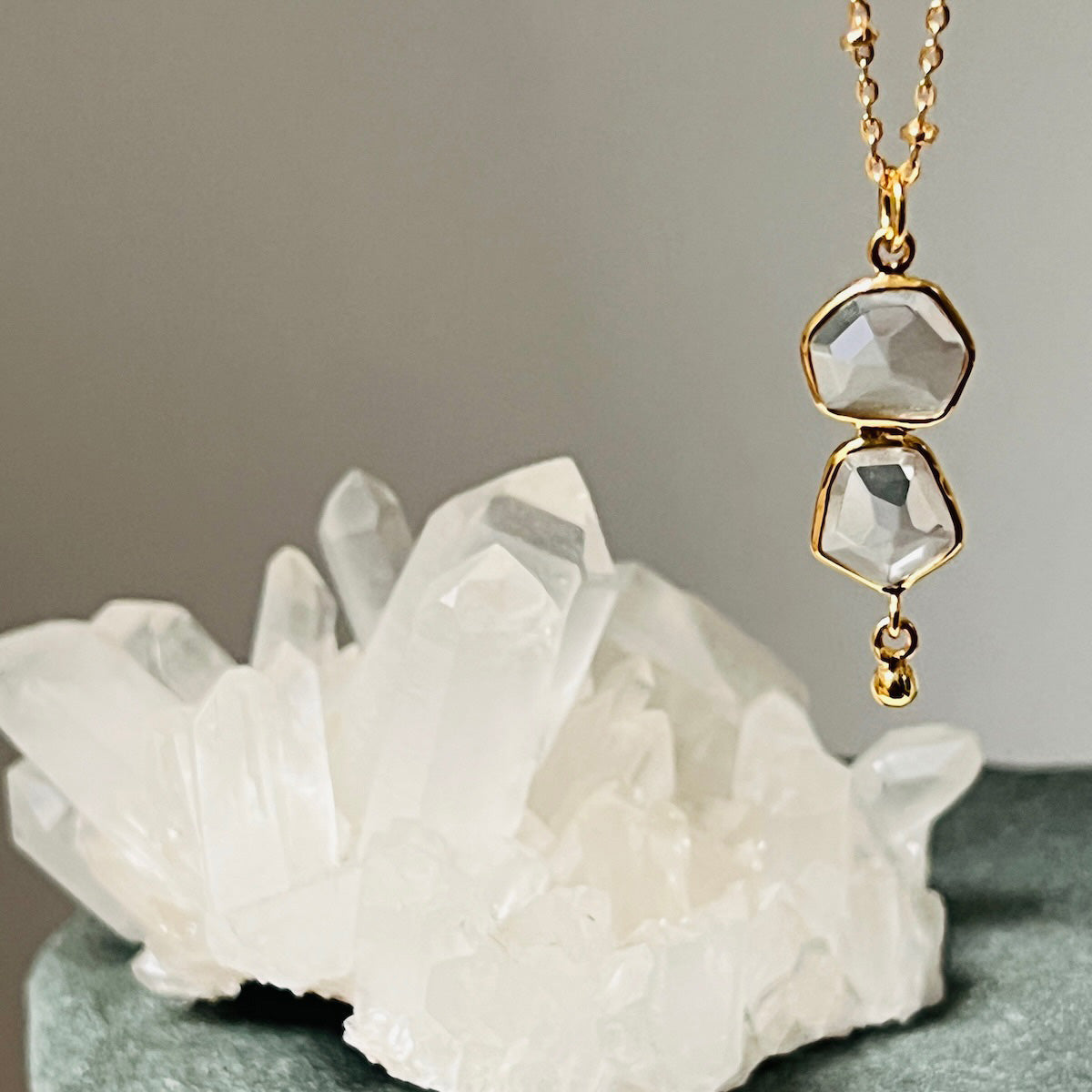 Gold necklace with faceted pendant on a crystal background