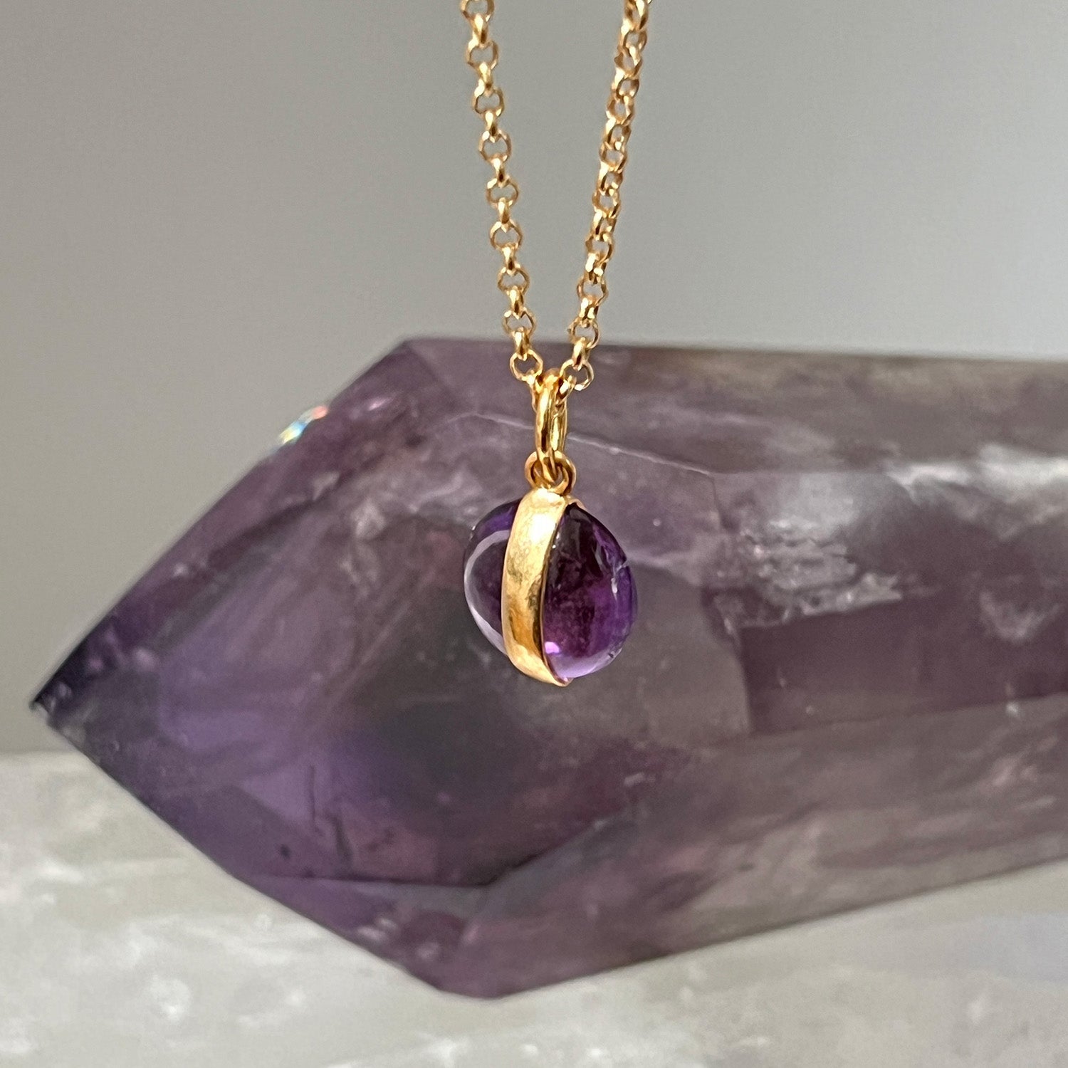 Gold necklace with a purple amethyst pendant