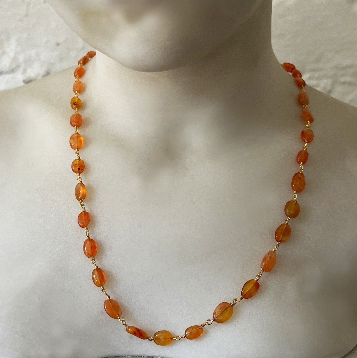 Mirabelle Jewellery Rosary necklace featuring orange carnelian pebble stones on a 22ct gold plated brass chain.