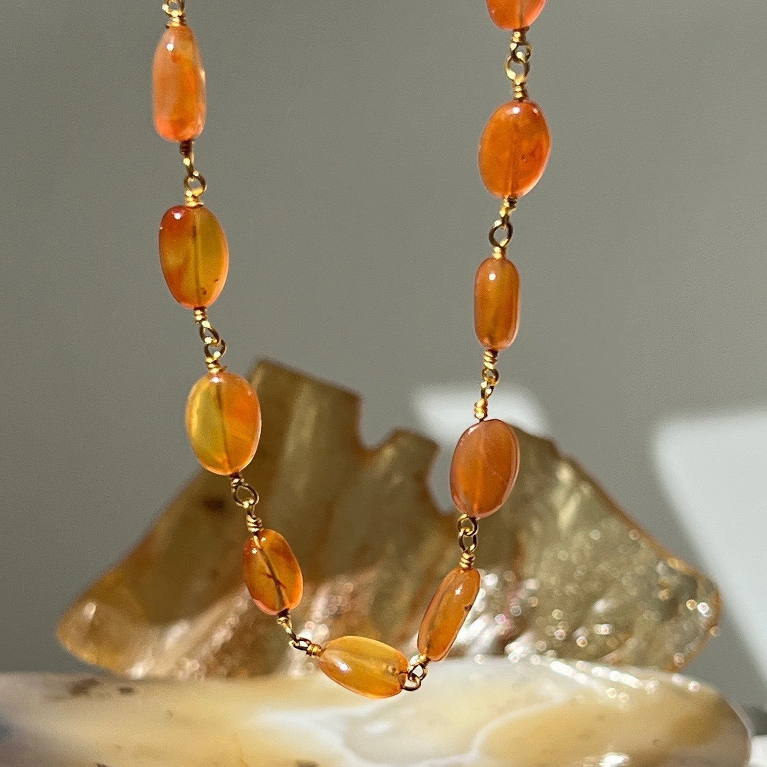 Mirabelle Jewellery Rosary Pebble necklace featuring orange carnelian stones on a 22ct gold plated brass chain.