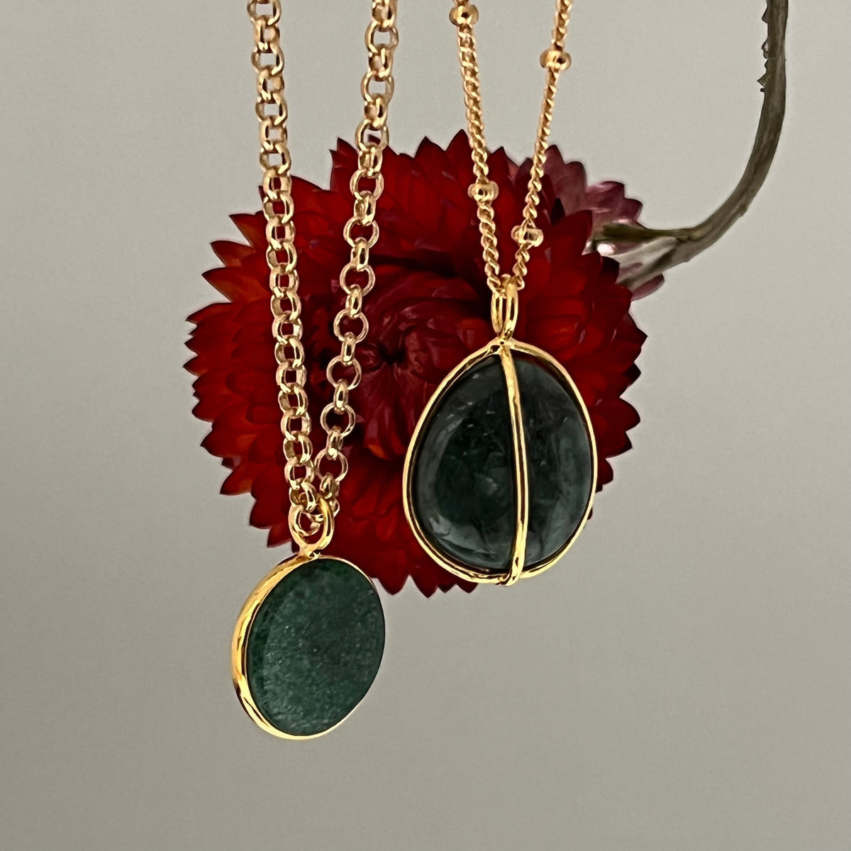 Mirabelle Jewellery freeform tumbled emerald pebble pendant on a gold satellite chain, with a second round emerald pendant.