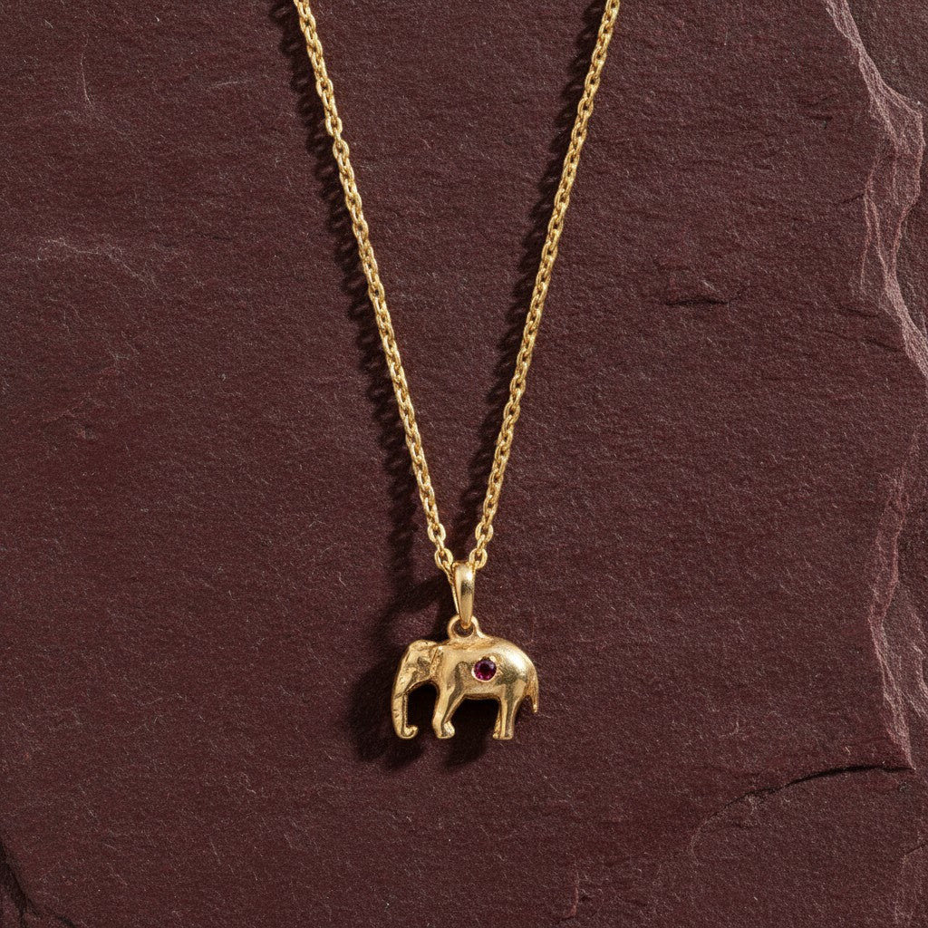 Mirabelle Jewellery 22ct gold plated brass tiny elephant pendant necklace featuring a small ruby gemstone.