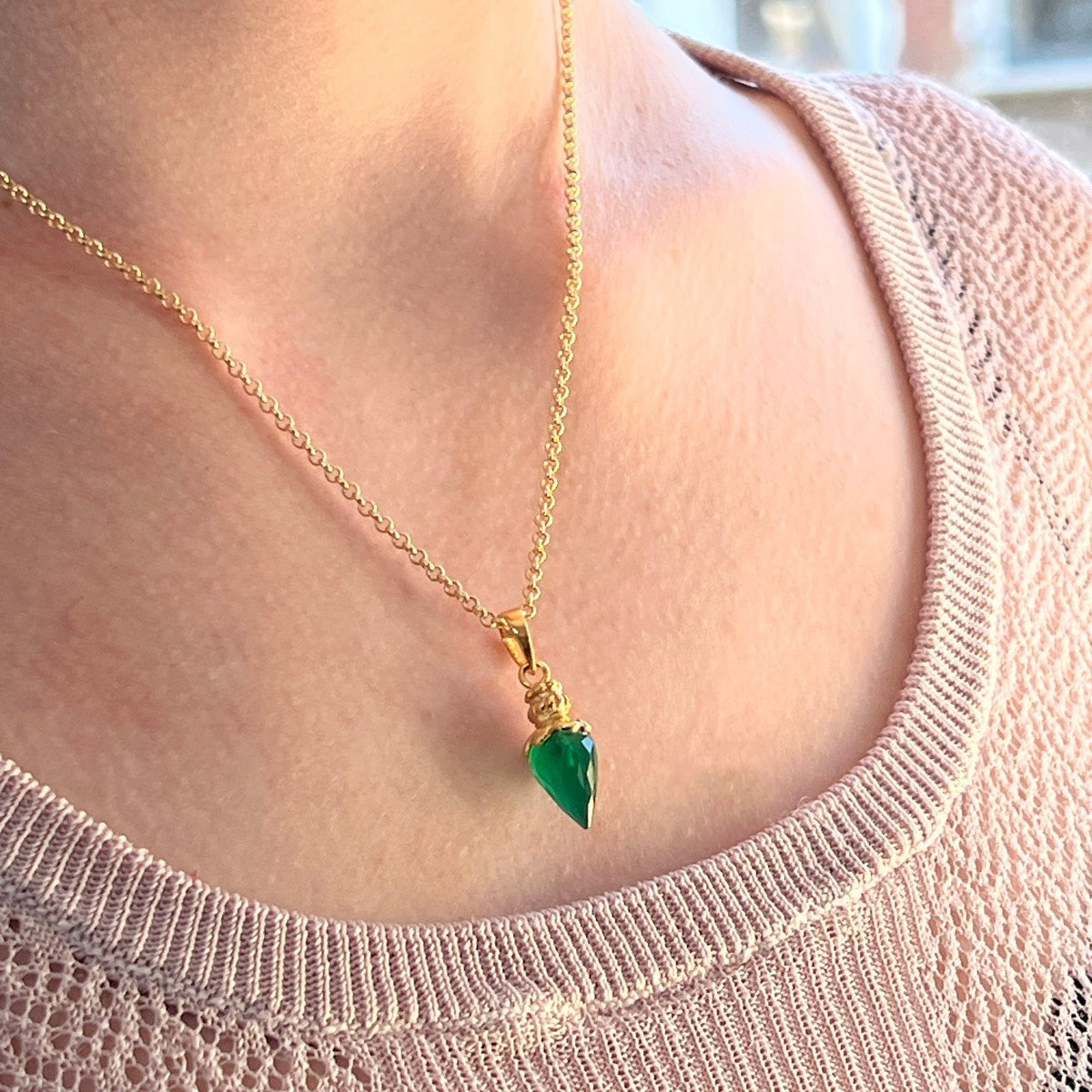 Mirabelle Jewellery green onyx pendulum pendant on a short gold-plated brass baby belcher chain worn by a woman.