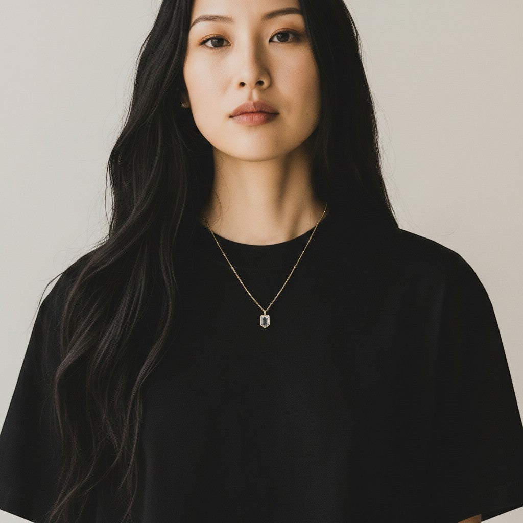 Model wearing a gold-plated Mirabelle Jewellery Mini Temple necklace with a clear rock crystal pendant on a chain.