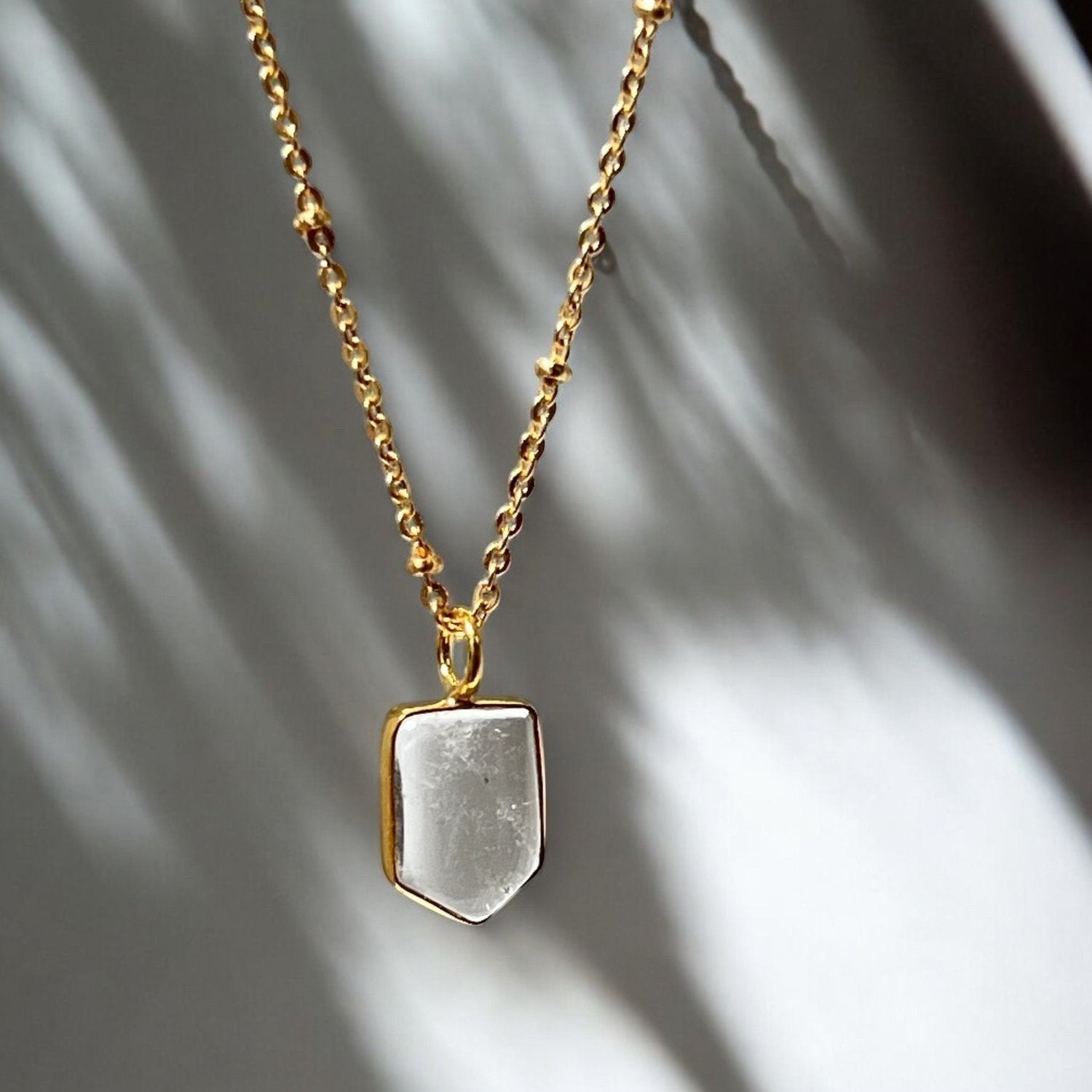 Mirabelle Jewellery gold-plated brass necklace featuring a mini rock crystal temple pendant on a satellite chain.