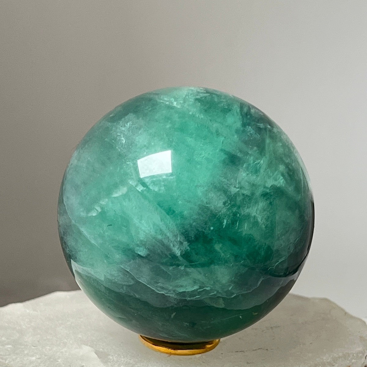 Mirabelle Jewellery polished green fluorite sphere with natural variations in color, smooth surface.