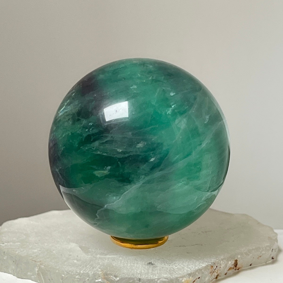 Mirabelle Jewellery polished green fluorite sphere with natural emerald and jade hues, smooth surface, ideal for meditation and decor.