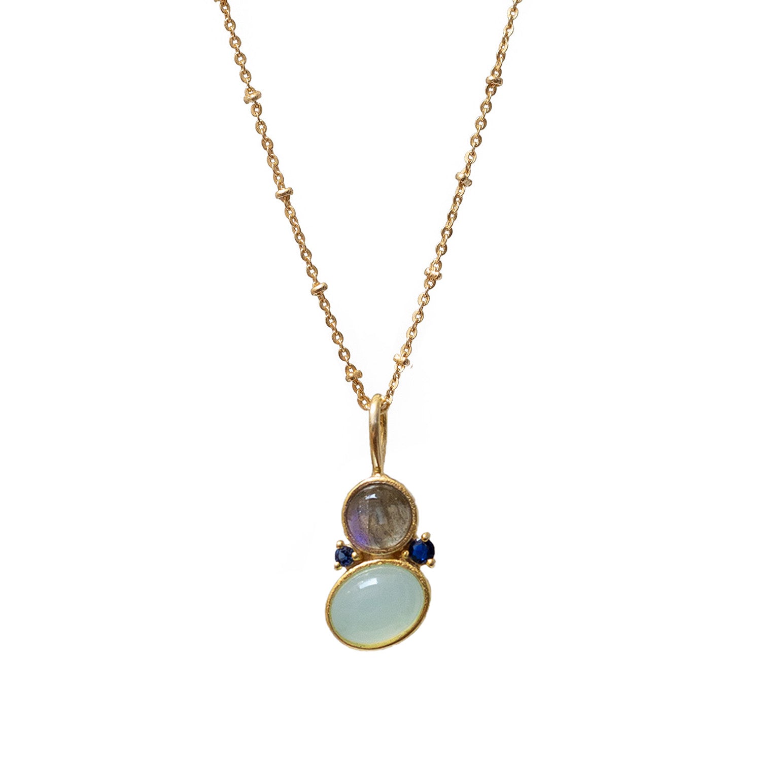 An asymmetric pendant necklace with three stones: Aqua Chalcedony, Labradorite, and Blue Zircon, set in gold-plated brass settings on a gold-plated chain.