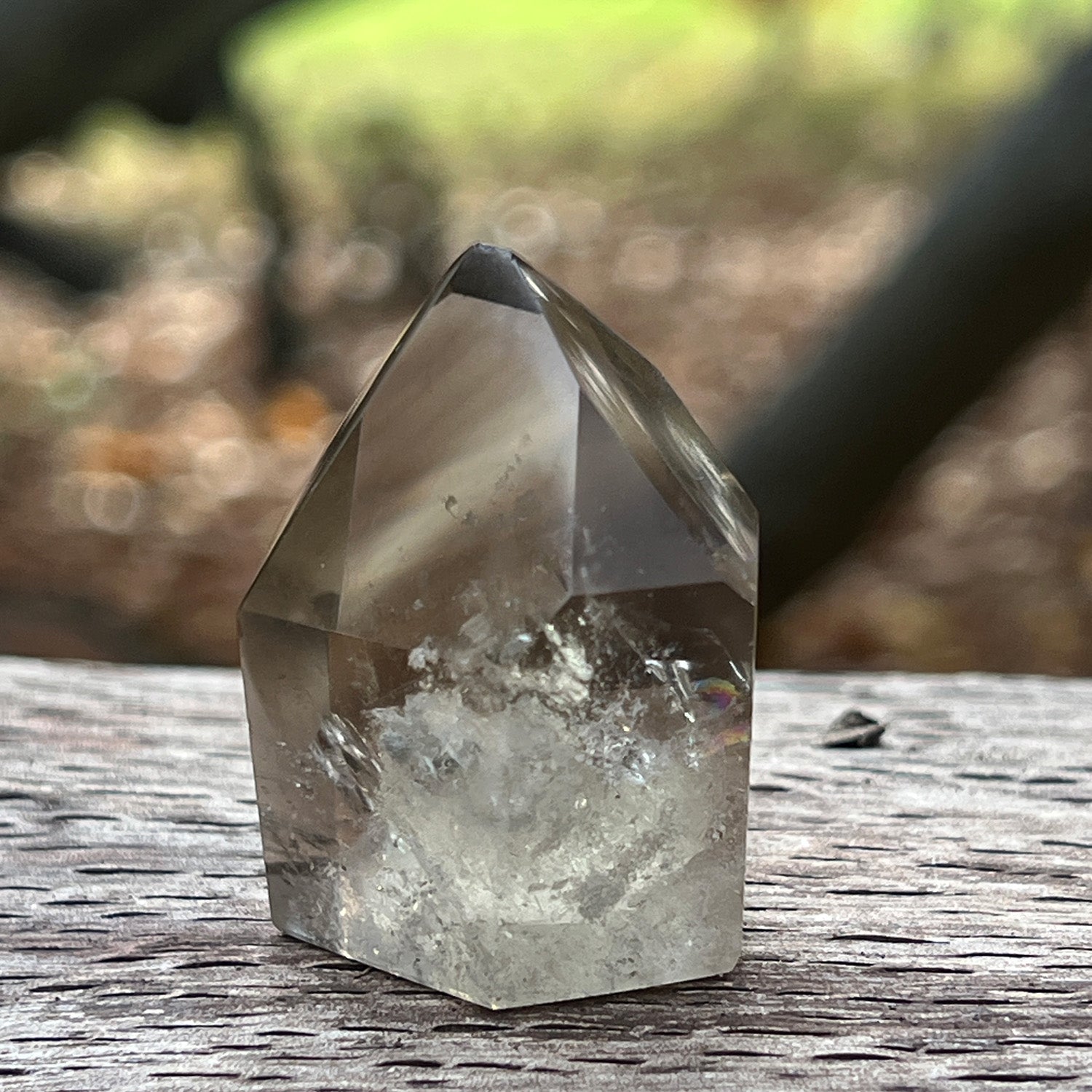 Citrine phantom quartz on a wooden surface with a blurred natural background