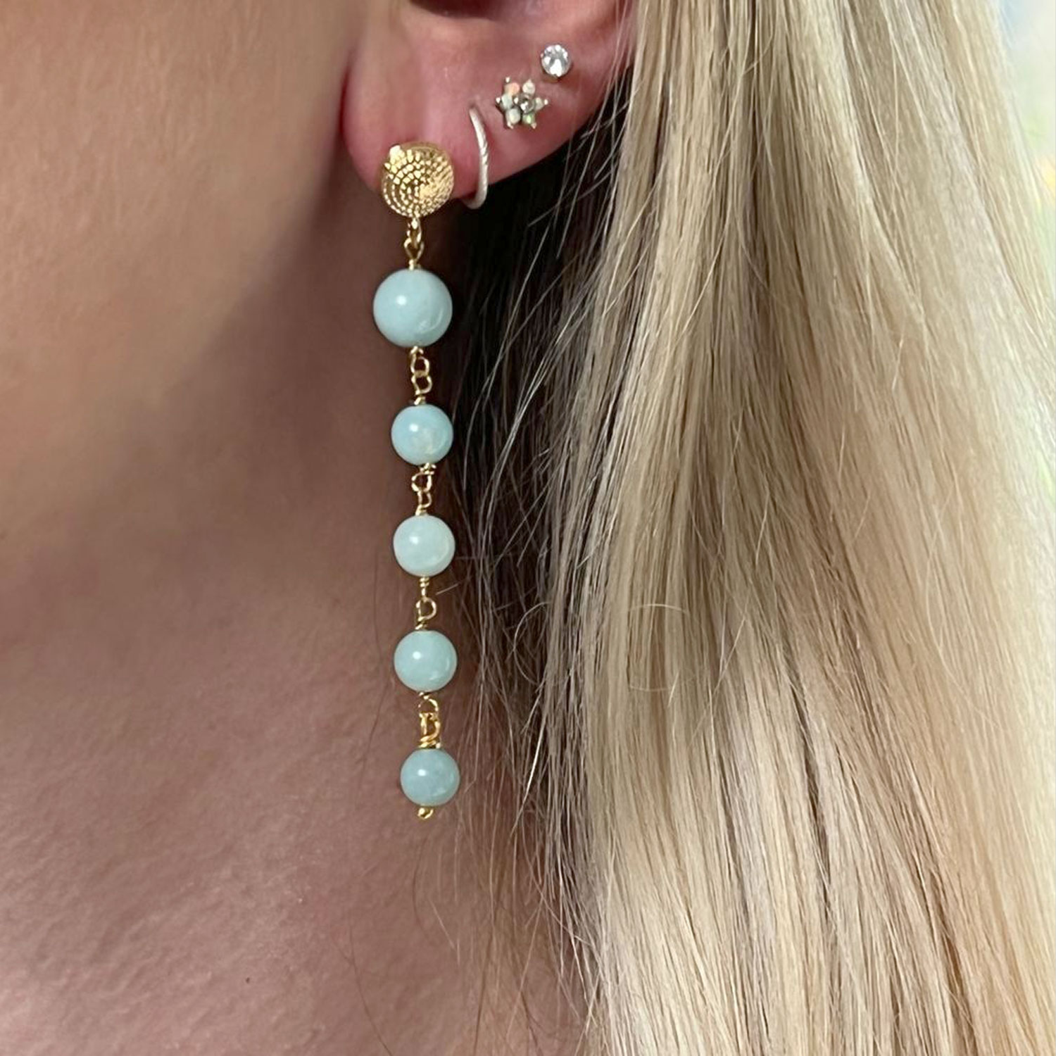 A close up of a model's ear wearing a 5 Stone Amazonite Earring