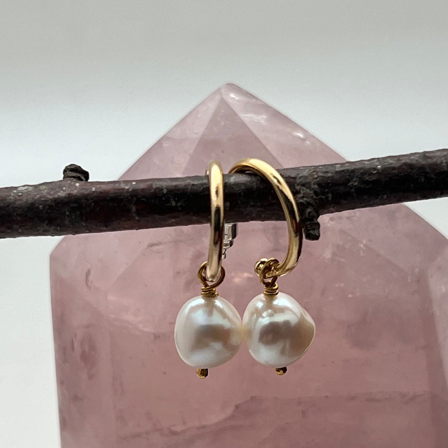 Baroque Pearl Creole Gold-Plated Hoop Earrings hanging from a twig