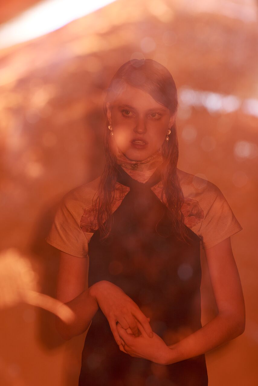 A model wearing beautiful 22ct gold-plated earrings with a flower design and coral freshwater pearls.