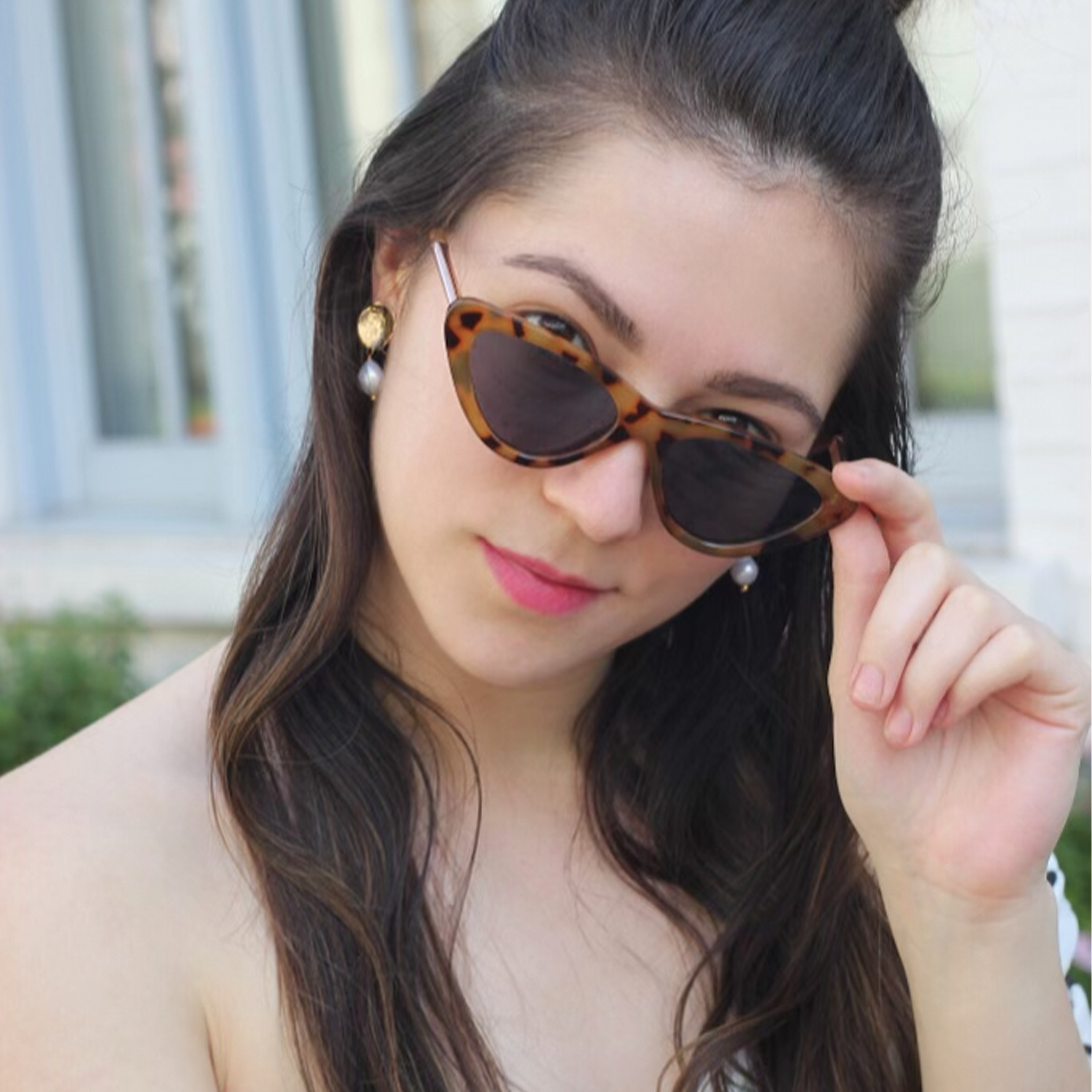 A model wearing beautiful 22ct gold-plated earrings with a flower design and coral freshwater pearls.