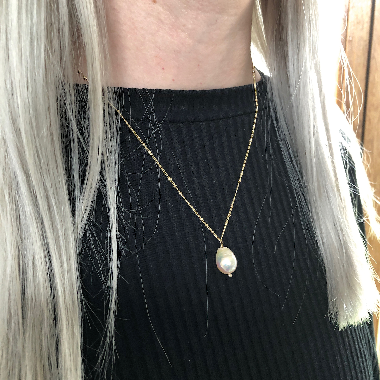 Baroque Pear Pearl on Mini Biba Gold-Plated Chain worn around the neck of a model wearing a black jumper