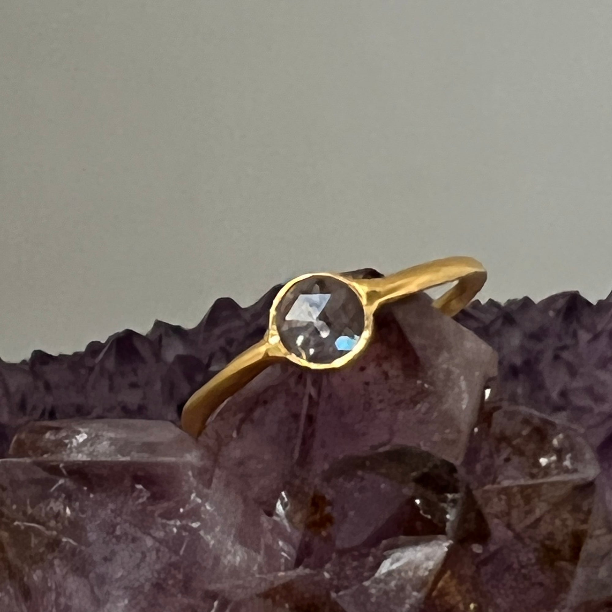 A gold-plated, vermeil-finished ring with a polki cut crystal centerpiece on a bed of crystals.