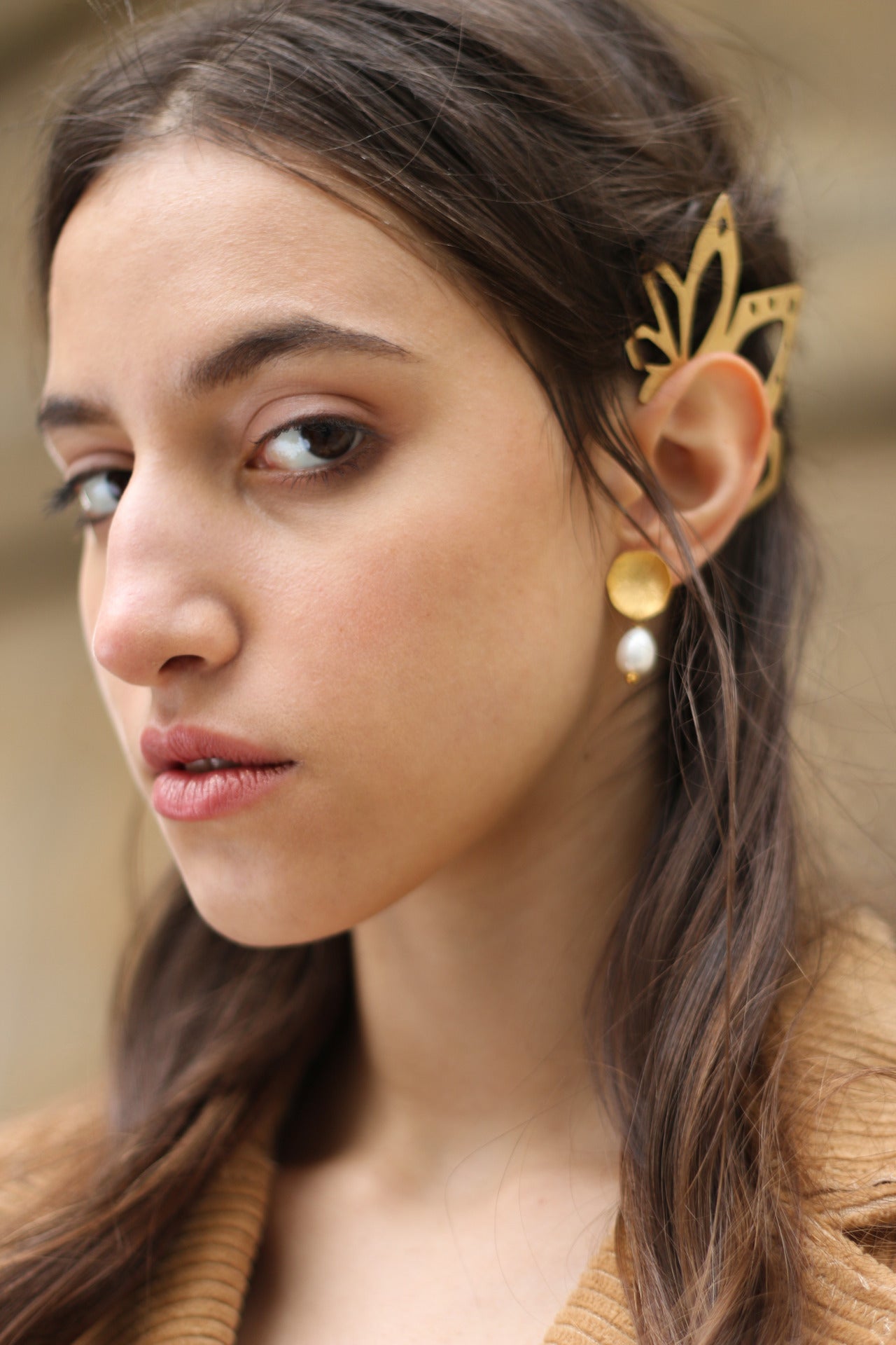 A model wearing beautiful 22ct gold-plated earrings with a flower design and coral freshwater pearls.
