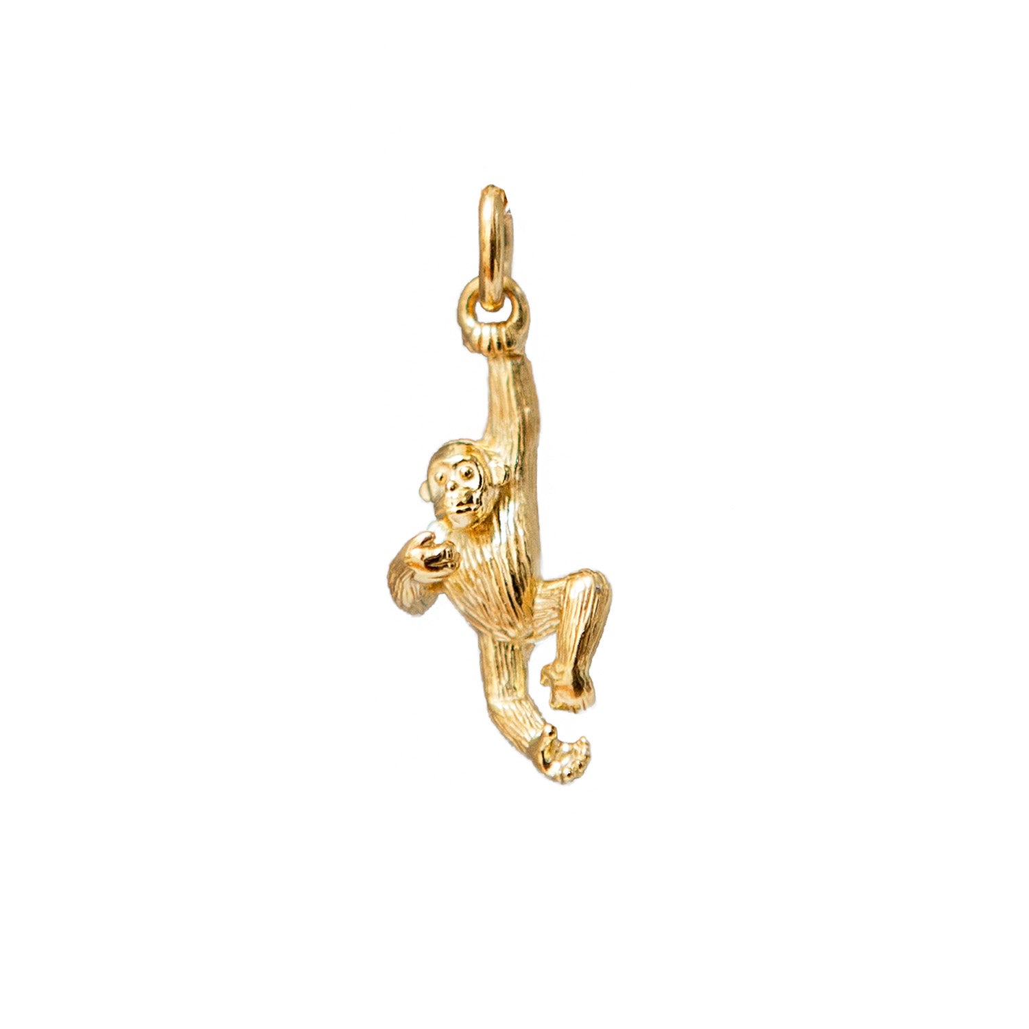 Gold monkey pendant on a white background