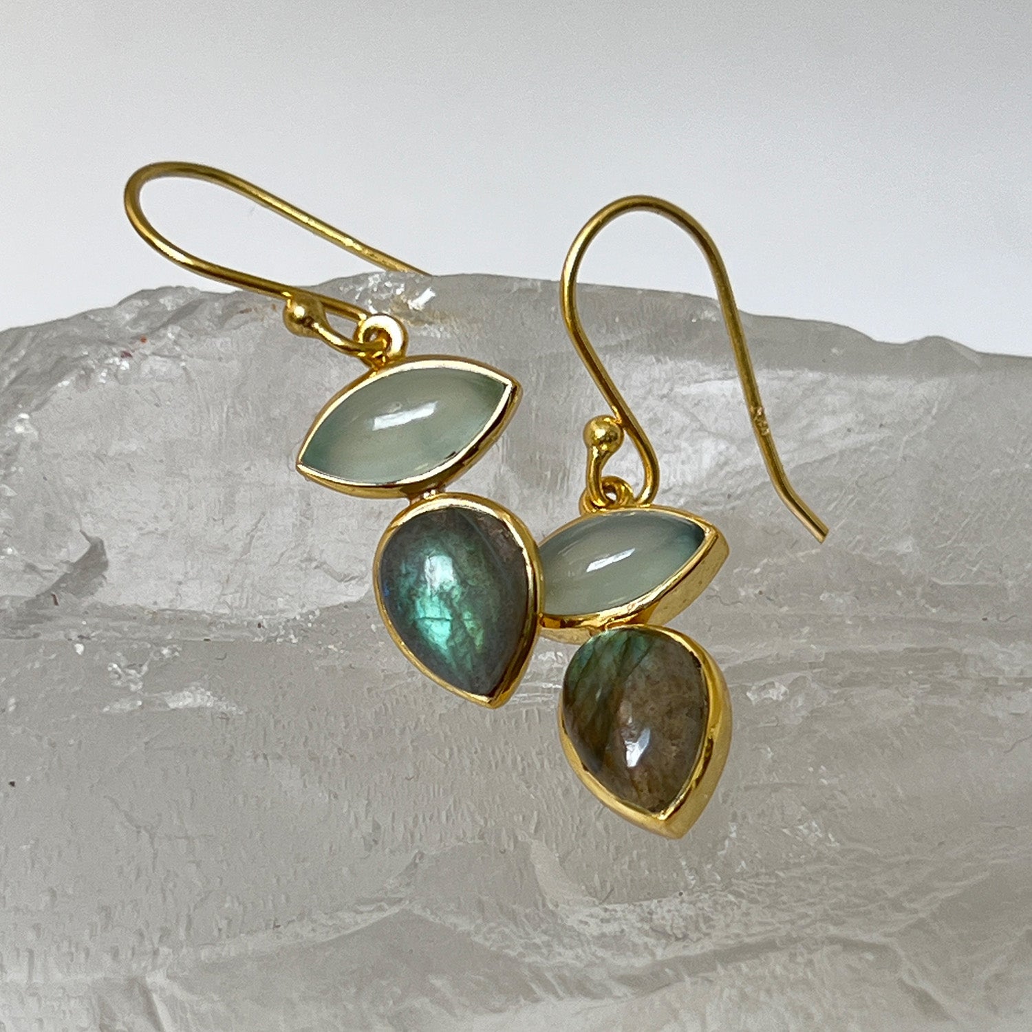Gold-plated earrings with labradorite and aqua chalcedony on a crystal background