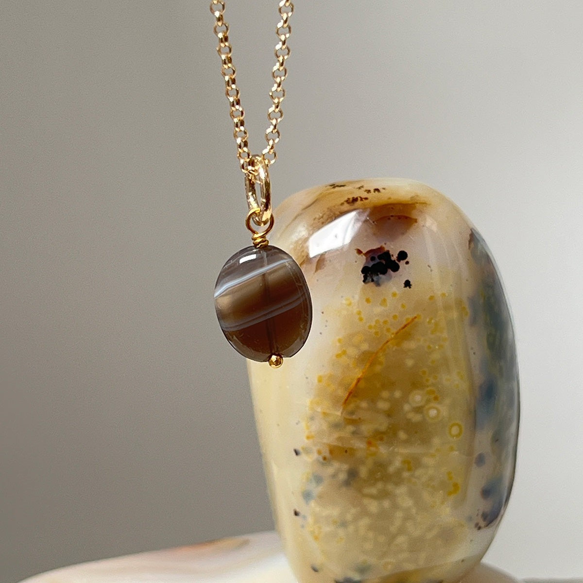 Mirabelle Jewellery small freeform Botswana agate pendant with natural earthy brown and white bands on a 22ct gold plated brass chain.