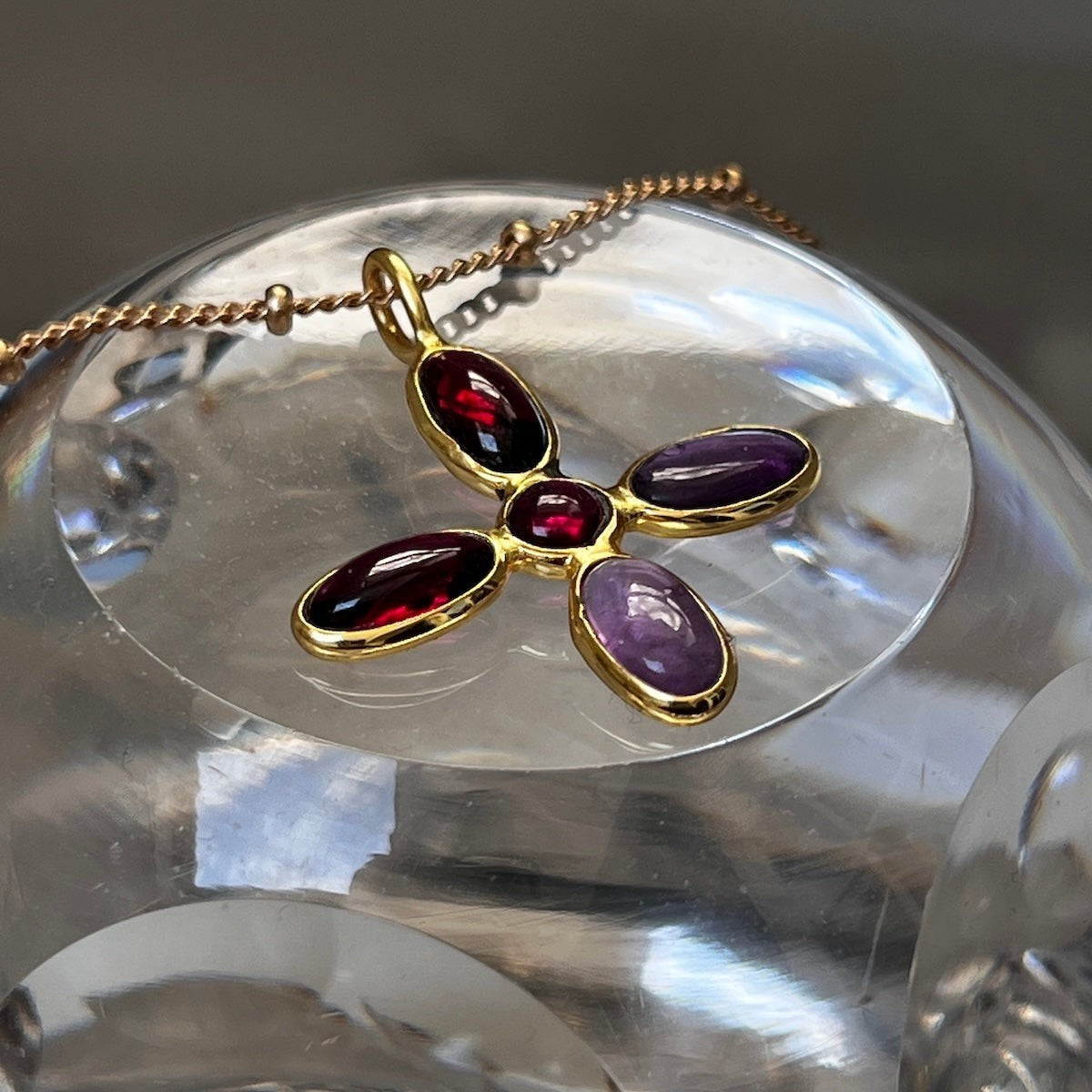 Mirabelle Jewellery large cross pendant with amethyst and garnet stones on a gold-plated brass rosary chain.