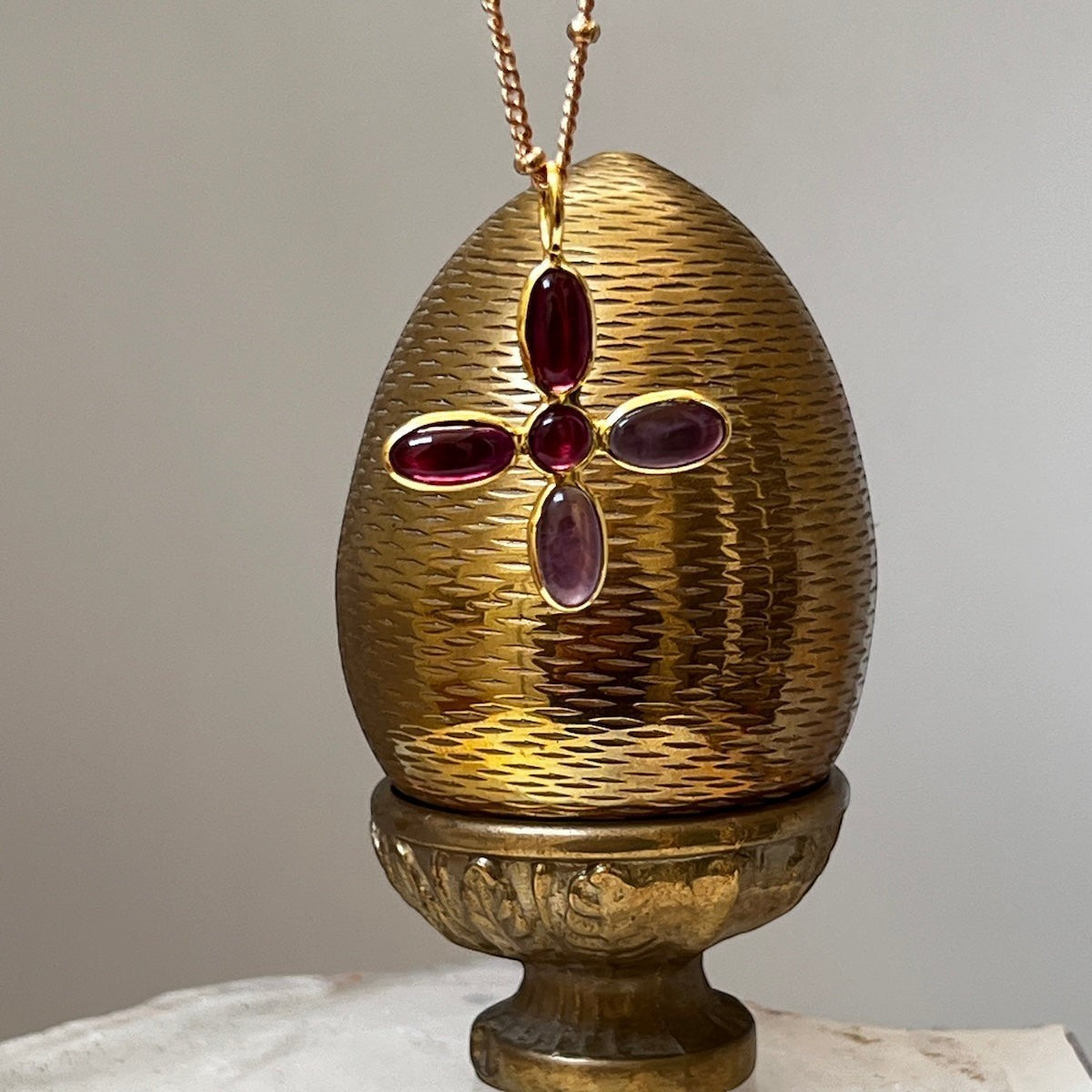 Mirabelle Jewellery large cross pendant with amethyst and garnet stones on a gold-plated brass rosary chain.