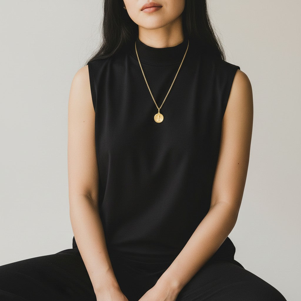 Mirabelle Jewellery Mary medal pendant on a long 22ct gold plated brass baby belcher chain worn by a woman