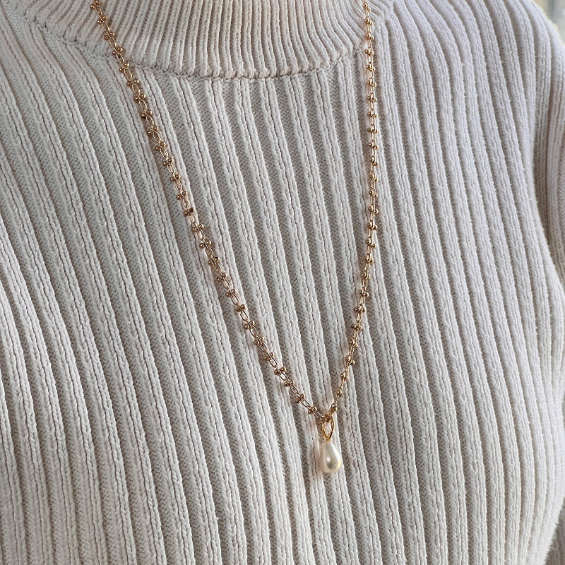 Freshwater pearl pendant necklace on a gold-plated bula chain worn on an ivory sweater