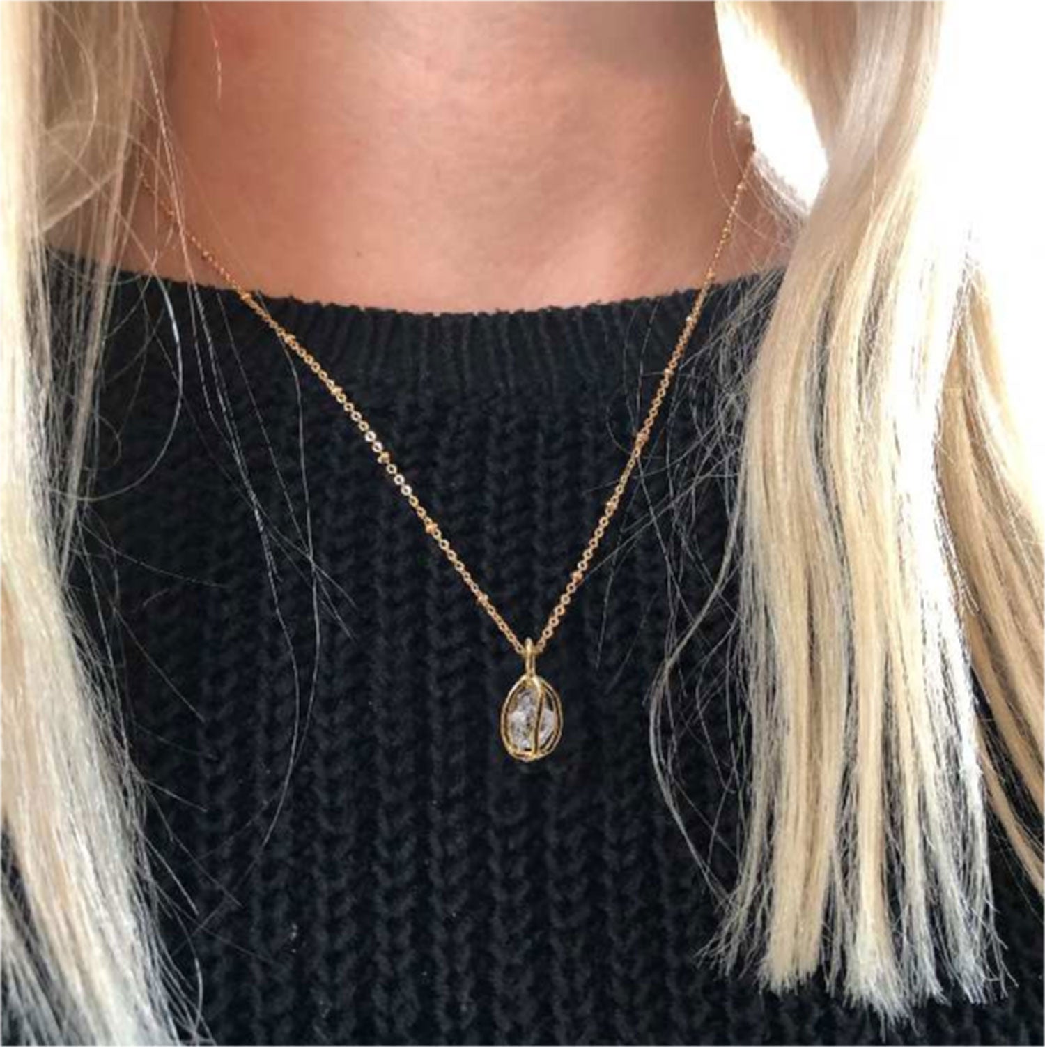 Raw Herkimer Quartz Diamond Gold-Plated Cage Pendant on a short chain worn on a model wearing a black jumper.